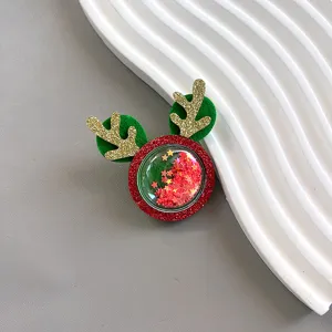 Christmas glitter deer antler hair clip close-up, red and green festive hair accessories detail.
