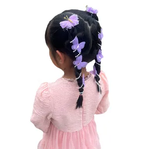 Vue détaillée de jolies pinces à cheveux papillon violettes avec des chaînes de perles pour tresses.
