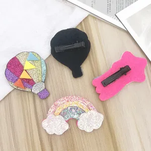 Children glitter hair clips detail view showing rainbow and hot air balloon barrettes.
