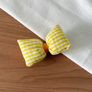 Vue détaillée du joli nœud papillon à carreaux jaune et blanc, texture en tissu doux.