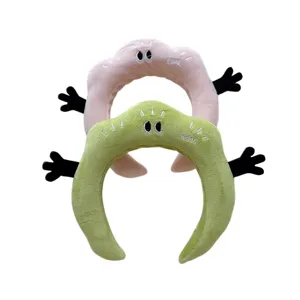 Détail de bandeau en peluche douce avec design de main drôle pour le lavage du visage quotidien.