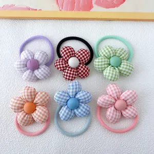 Close-up detail of cute colorful plaid fabric flower hair scrunchies, soft elastic hair ties.