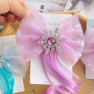 Kids hair clip detail view featuring purple mesh bow, rhinestone snowflake and cute hair extensions.