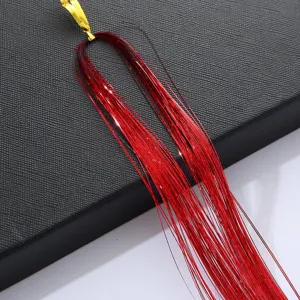 Détail d'extension de tinsel de cheveux rouges étincellants, idéal pour coiffure tendance.
