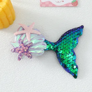 Detailed view of kids mermaid tail hair clip with sparkling sequins, shell and cute starfish.