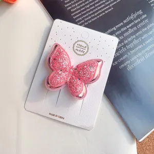Detailaufnahme einer rosa glitzernden doppelten Schmetterlings-Haarspange auf Karte.