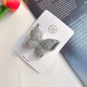 Detaillierte Nahaufnahme der glitzernden doppelten Schmetterlings-Haarspange mit feinem Glitzer-Design.