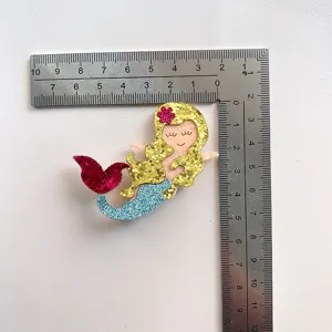 Glitter mermaid tail hair clip accessory, cute cartoon fabric patch for kids hair styling.