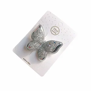 Detaillierte Ansicht der glitzernden silbernen Schmetterlingshaarspange auf Displaykarte.
