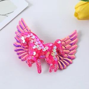 Close-up shot of the cute pink sequin unicorn hair clip with shiny angel wings detail.