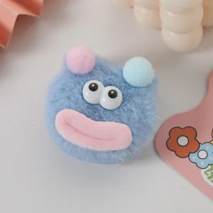 Gros plan détaillé d'une jolie pince à cheveux monstre bleu pelucheux avec grands yeux.