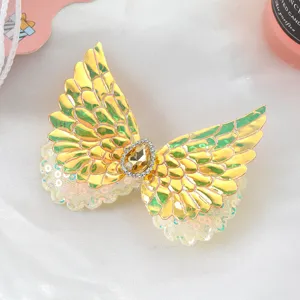 Detail view of cute angel wings baby hair clip with rhinestones and sequins for girls.