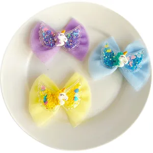 Details of colorful tulle bow hair clips with glitter unicorn and angel wings for girls.