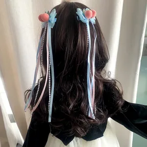 Deliziose mollette per capelli pesca con fiocchi blu e nappe di perle, accessorio dolce.