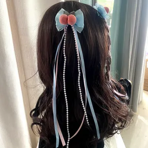 Vista dettagliata del bellissimo fermaglio per capelli con fiocco blu, pesca e perle.