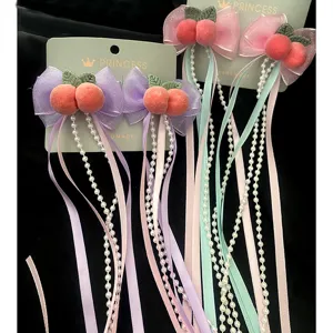 Deliziose mollette per capelli con fiocco, nappe di perle e decoro pesca per look dolci.