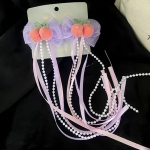 Dolci fermagli per capelli con pesca, fiocchi e lunghi nastri di perle per look eleganti.
