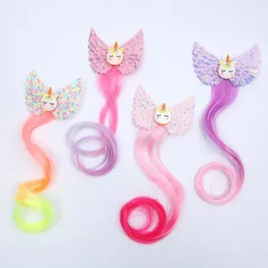Close-up view of colorful sequin unicorn wing hair clips with long hair extensions for kids.