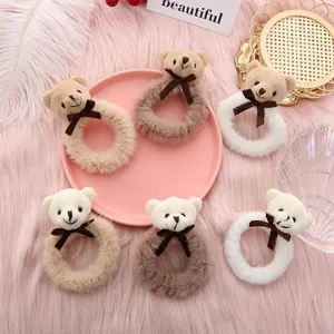 Cute plush bear hair scrunchies detail view showing soft fluffy texture and brown bow knots.