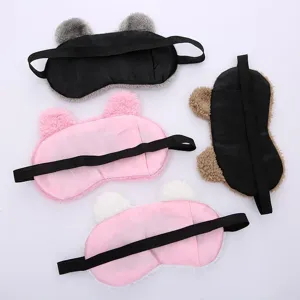 Cute cartoon bear plush sleep mask detail shot, soft teddy fleece eye cover with elastic strap.