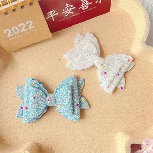 Glitter bow hair clips for kids, sparkly hair accessories in blue and white, cute hair pins.