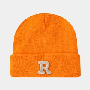 Bonnet en tricot orange vif avec lettre R blanche brodée élégante pour l'hiver et l'automne.