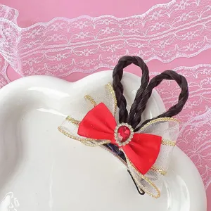Chic red bow hair clip featuring black braided hair and sparkling red crystal centerpiece.