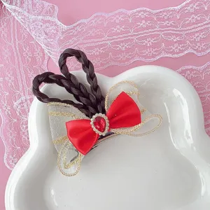 Detailed view of cute children hair clip with red bow, braided hair and sparkling gem accent.