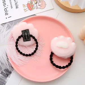 Close-up view of cute plush cat paw hair tie with soft pink texture and secure elastic band.