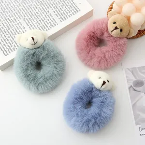 Detail view of cute plush bear hair scrunchy, soft fluffy texture, cozy aesthetic flat lay.