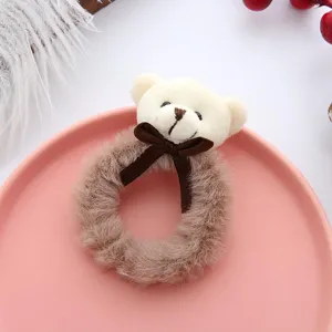 Gros plan détaillé d'un chouchou en peluche avec un petit nœud marron sur une assiette rose.