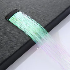 Close-up detail of colorful holographic hair tinsel extension strand with black clip.