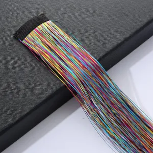 Detail of colorful laser tinsel hair extensions with black clip for shiny braids.