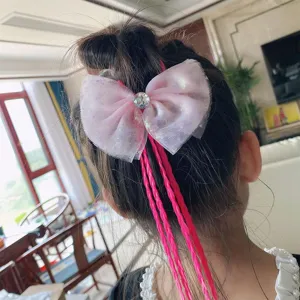 Pink bow hair accessory with colorful braided hair and rhinestone detail, shown worn in hair.