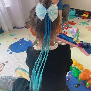 Detailed view of the kids' blue bow hair extension with long braided colored braids.