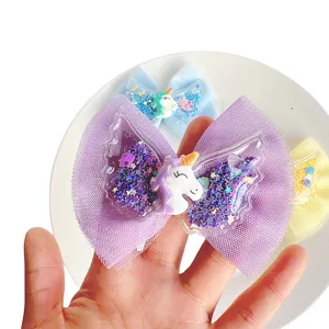 Detailed view of children mesh bow hair clip with cute unicorn and sparkling wings design.