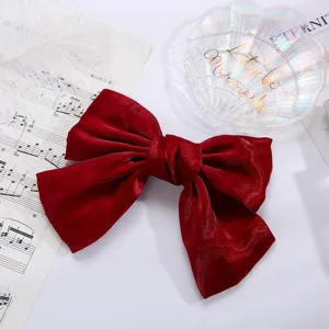 Elegante molla per capelli con grande fiocco in velluto rosso, accessorio donna chic.