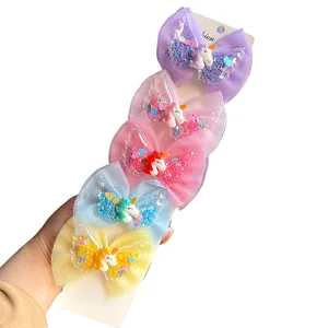 Close-up detail of colorful unicorn mesh bow hair clips featuring cute angel wings design.