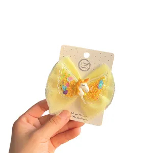 Cute unicorn mesh bow hair clip detail, featuring colorful wings and glitter for girls.