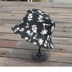 Detailed view of the black cotton bucket hat featuring white tropical palm tree and flamingo prints.