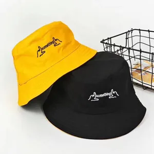 Vue détaillée de chapeaux bob en coton avec motif brodé, disponibles en jaune et noir.