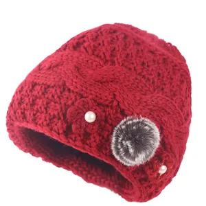 Red winter knitted hat for women, warm fleece-lined beanie with pom-pom and pearl decor.