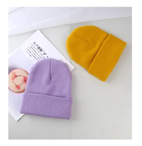 Inquadratura dettagliata di berretti in maglia accoglienti, viola e giallo, inverno.