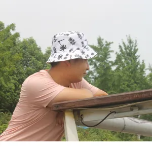 White bucket hat with black palm tree print, casual cotton sun hat for outdoor travel wear.