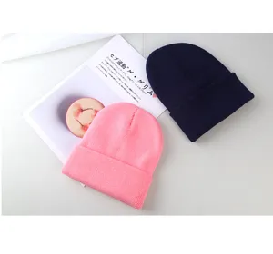 Vista dettagliata di berretti in maglia tinta unita rosa e blu scuro per calore e comfort invernali.