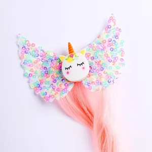 Cute unicorn wings hair clip detail, colorful sequins and pink wig strands for kids festival dress.