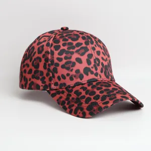 Close-up detail of a stylish red baseball cap featuring a bold black leopard print pattern.