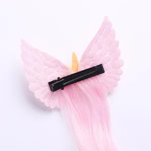 Close-up detail shot of pink unicorn wing hair clip with long synthetic hair extension