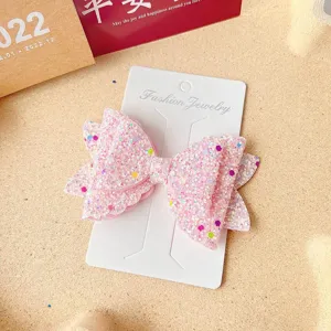 Pink glitter bow hair clip detail shot showing sparkling texture and multi-layer design.