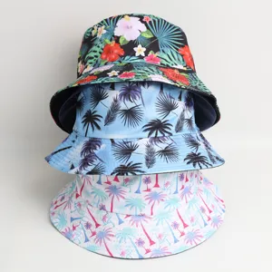 Close-up detail shot of stacked tropical print bucket hats featuring floral and palm tree designs.